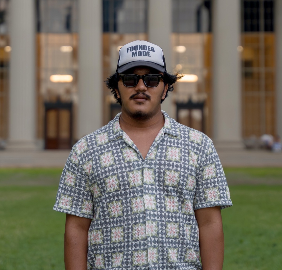 Sudip Rokaya wearing a Founder Mode cap in front of the MIT dome